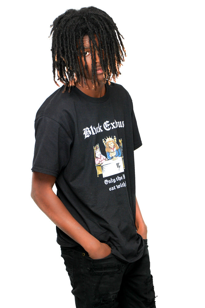 Male wearing Black short-sleeve t-shirt featuring a vintage-inspired graphic of animals sitting at a table with the text "Only the Hungry Eat with Kings" in a bold, gothic font, and the Blvck Exodus logo.