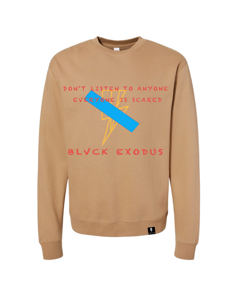 Men's tan crewneck sweatshirt featuring a bold graphic design with a blue stripe crossing out a lightning bolt and the phrase "Don't Listen to Anyone Everyone is Scared" in red text. The "Blvck Exodus" logo is displayed below the graphic.