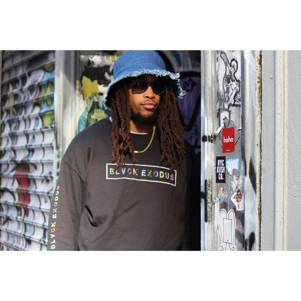 male wearing colorful retro design Black crewneck sweatshirt Black crewneck sweatshirt with a white box framing the Blvck Exodus logo in colorful text, and the logo repeated in colorful text on the sleeves
